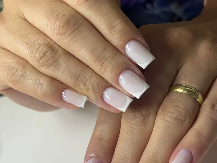Mãos com unhas em francesinha branca feitas no estúdio